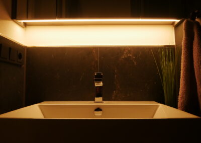 Abendstimmung im Badzimmer, Waschbecken der Ferienwohnung mit gedimmtem Licht.
