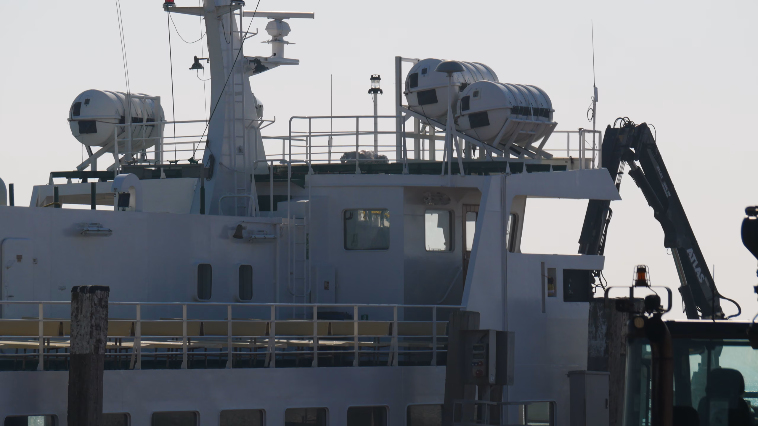 Fähre zwischen Wangerooge und Harlesiel Fähre bei hellem Licht mit Bänken an Deck und Rettungsinseln. Wird gerade mit Gepäck beladen.